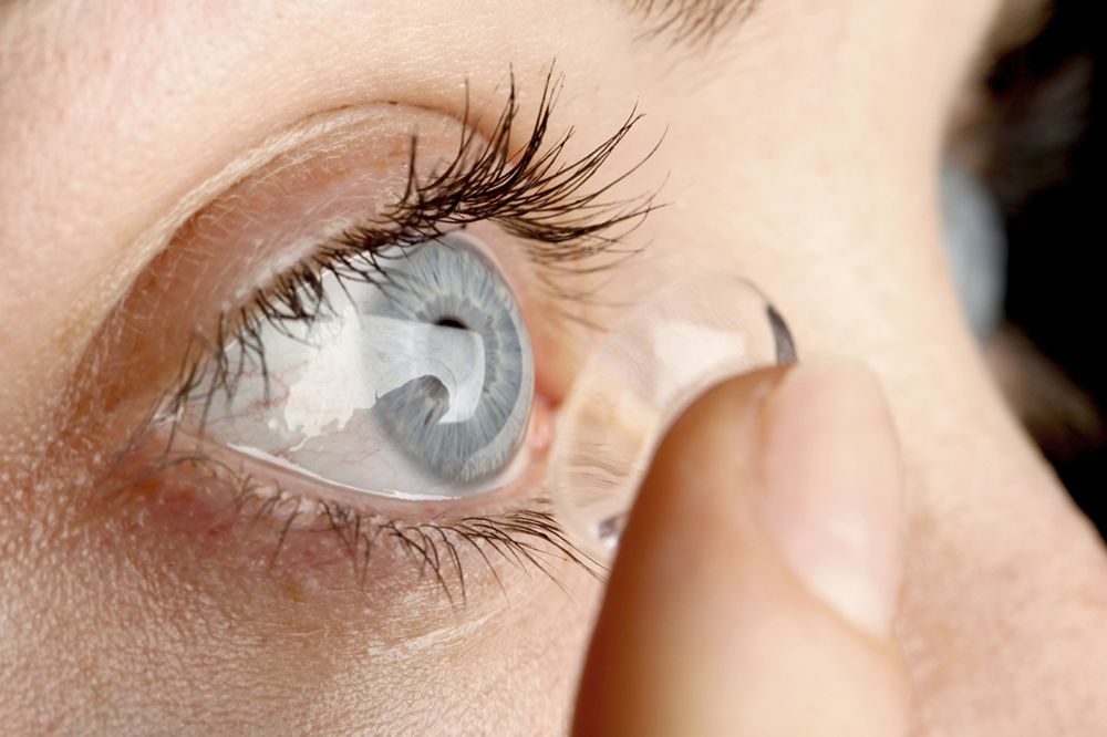 Close-up of woman putting in a contact lens